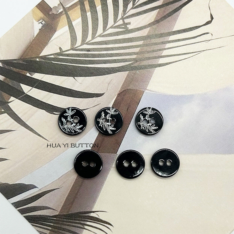 Assorted black 2-hole round shirt buttons with bamboo pattern, multiple pieces