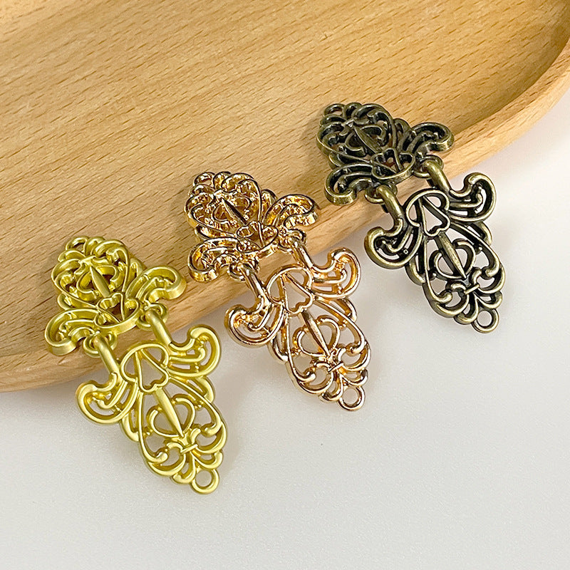 Ornate metal frog buttons, close view in bright gold, rose-gold, and dark bronze finishes