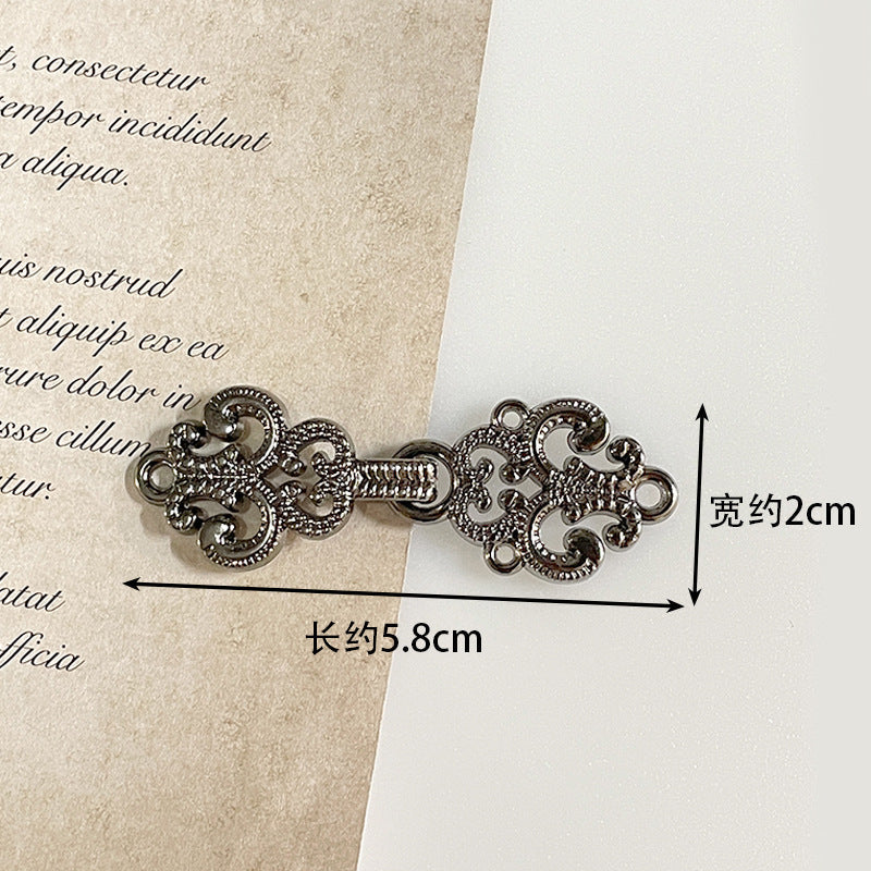 Antique silver metal frog button with ornate filigree toggle and decorative ring accents