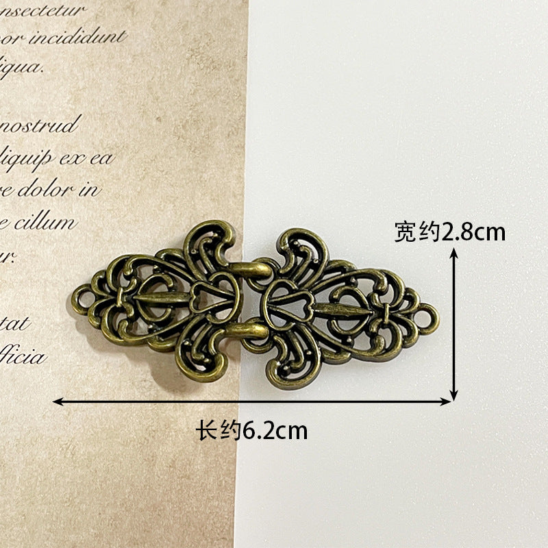 Dark bronze metal frog button with ornate filigree toggle and decorative ring accents