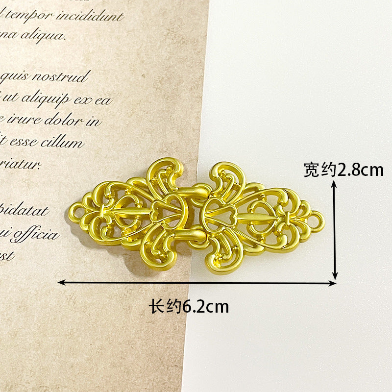 Bright gold metal frog button, ornate filigree toggle with heart-like cutout accents