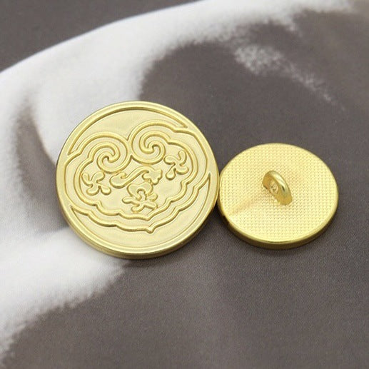 Gold round button front with ornate Chinese motif; back shows a sewing shank