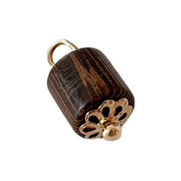 Wooden bead charm button, dark brown cylinder with gold ring and floral detail.