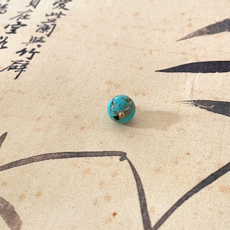 Turquoise jade-style round button with gold-tone shank, small carved look