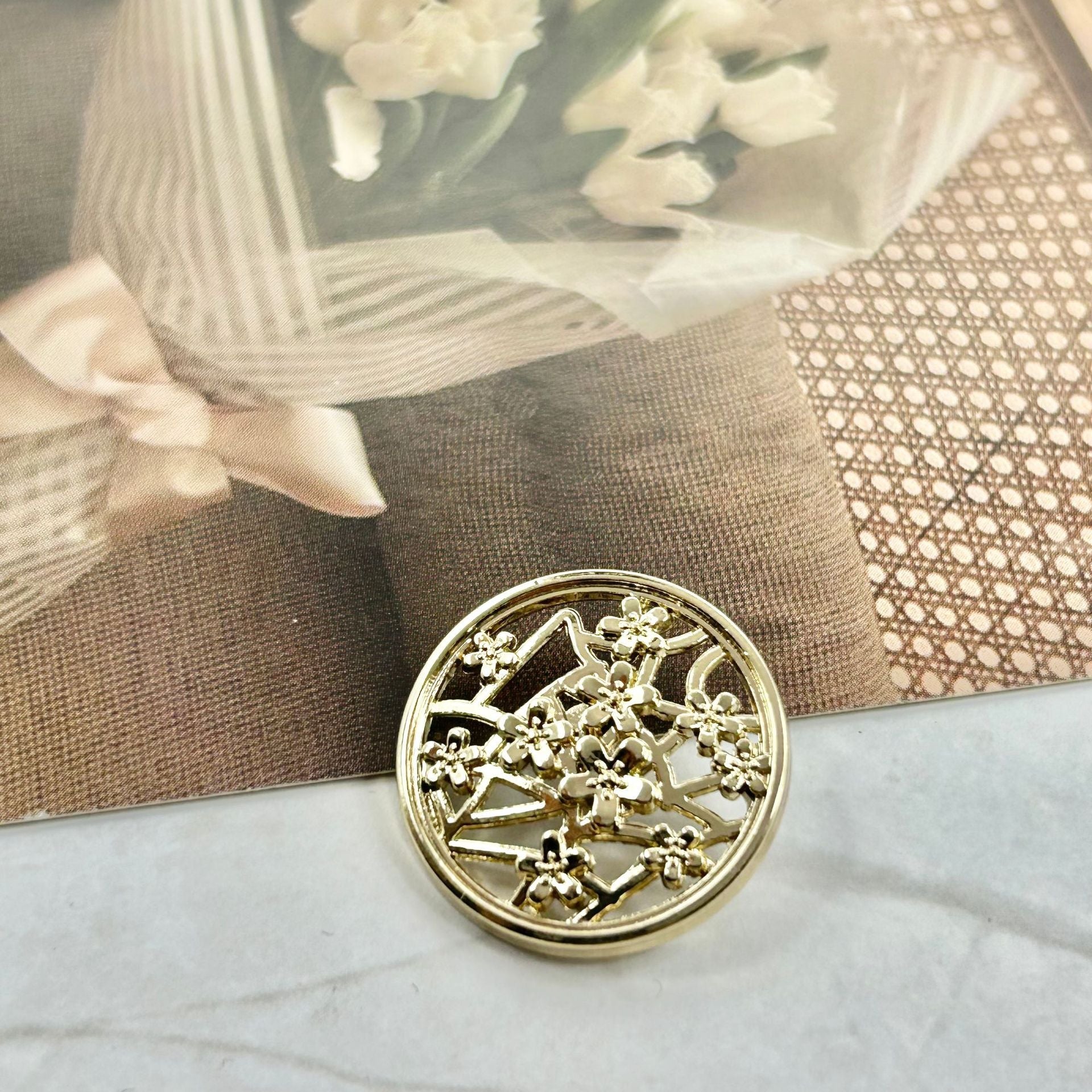 Gold metal button with plum blossom cutout design, round hollow shank back