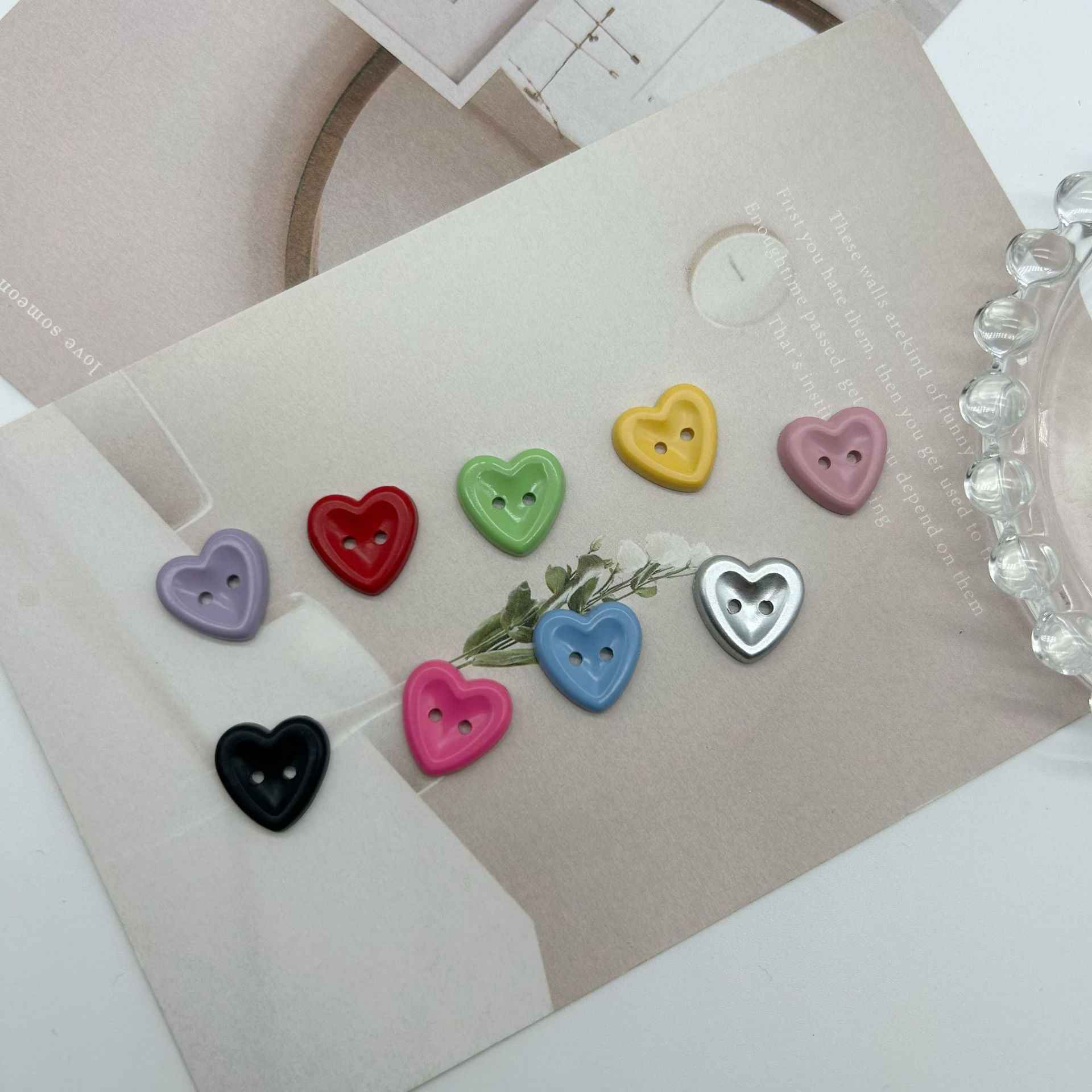 Heart buttons with two holes in assorted colors on craft cards