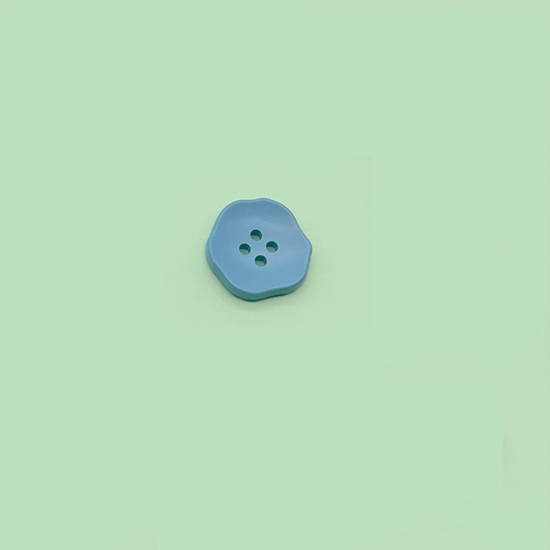 Light blue flower-shaped 4-hole plastic button for children’s clothing