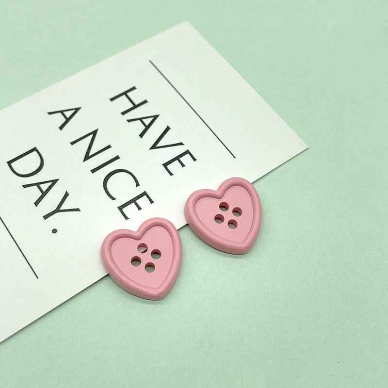 18mm four-hole heart buttons in pink with four stitch holes
