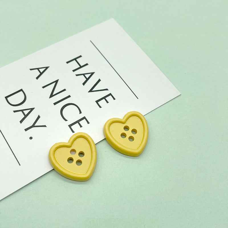 18mm four-hole heart buttons in yellow with four stitch holes
