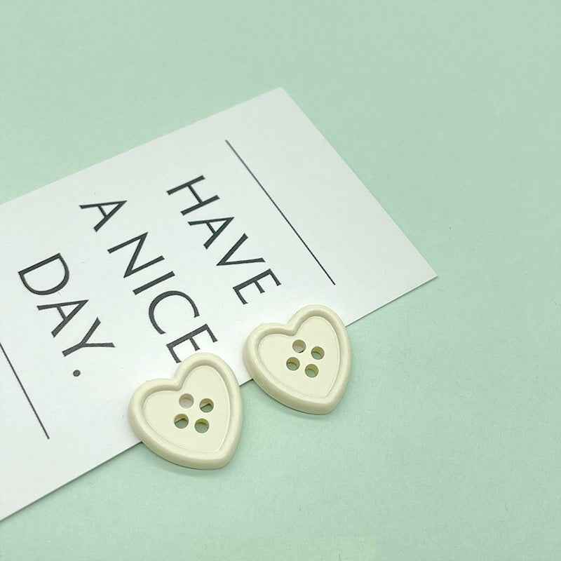 18mm four-hole heart buttons in cream/ivory with four stitch holes