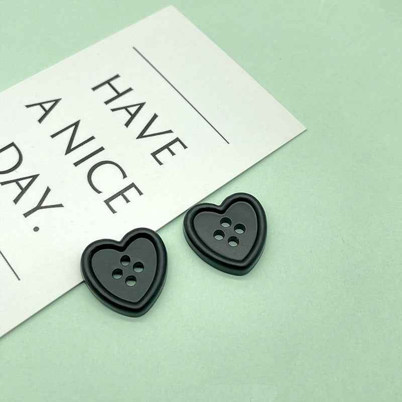18mm four-hole heart buttons in black with four stitch holes