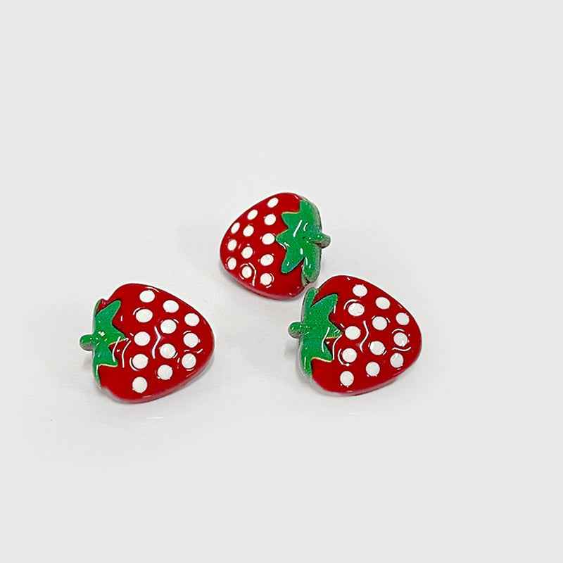 Three red strawberry cartoon shank buttons with white dots and green leaves