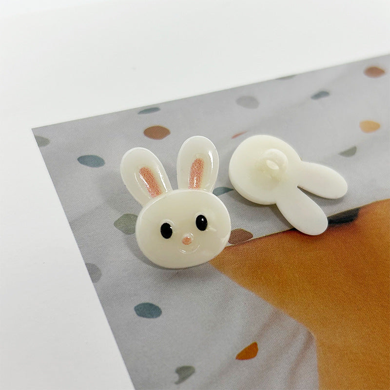 Pair of white bunny buttons with shanks, pink nose and black eyes