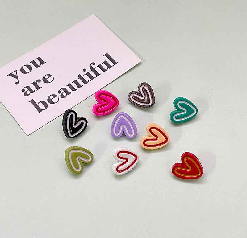Colorful double-heart plastic buttons for children’s clothing, multiple colors shown.