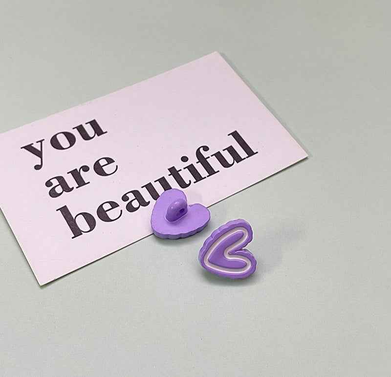 Lavender purple double-heart plastic button with rounded flat back and stitched look.