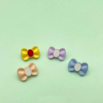 Colorful bow-shaped plastic buttons with shanks, yellow/red, lilac, peach, blue