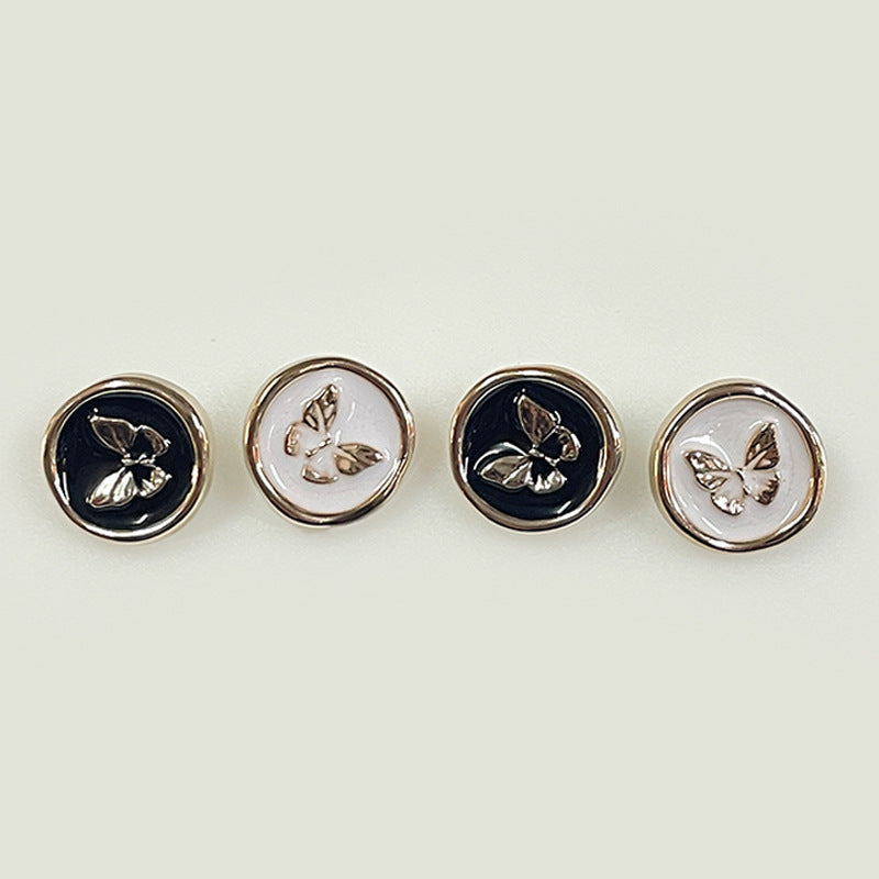 Set of round butterfly plastic shank buttons in black and white, silver-tone rims