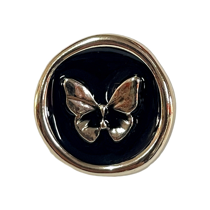 Round black plastic shank button with butterfly emblem, silver-tone rim
