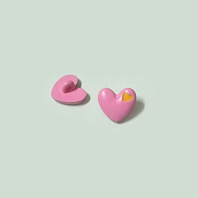 Pink heart-shaped buttons with shanks, small yellow inner-heart accent