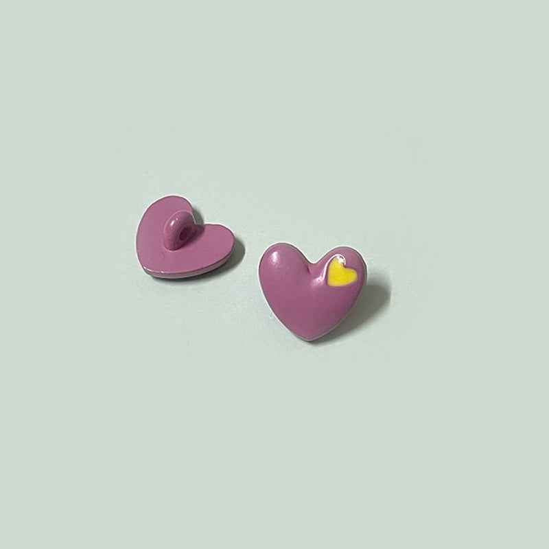 Magenta/pink heart-shaped buttons with shanks and yellow inner-heart accent