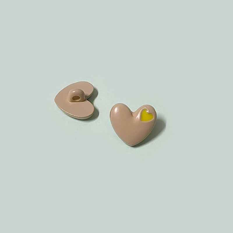 Beige/tan heart-shaped buttons with shanks and yellow inner-heart accent