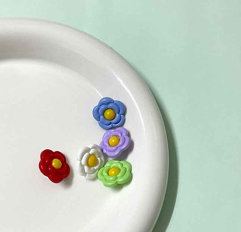 Set of flower-shaped plastic shank buttons in blue, purple, white, green, and red