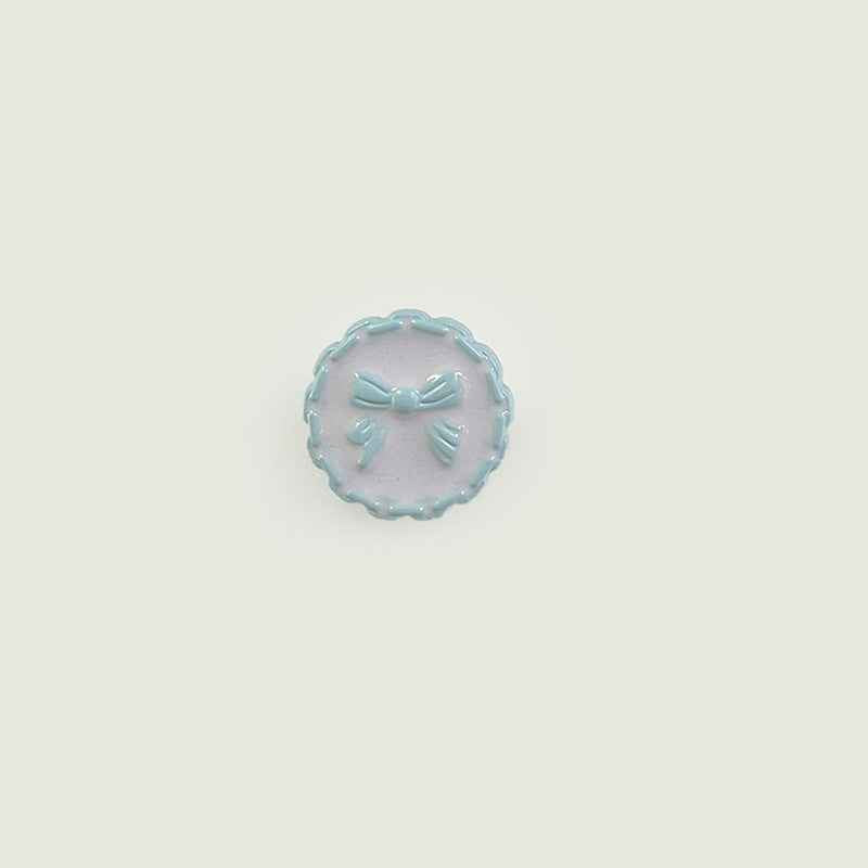 18mm plastic button with chain edge, light-blue face, bow detail