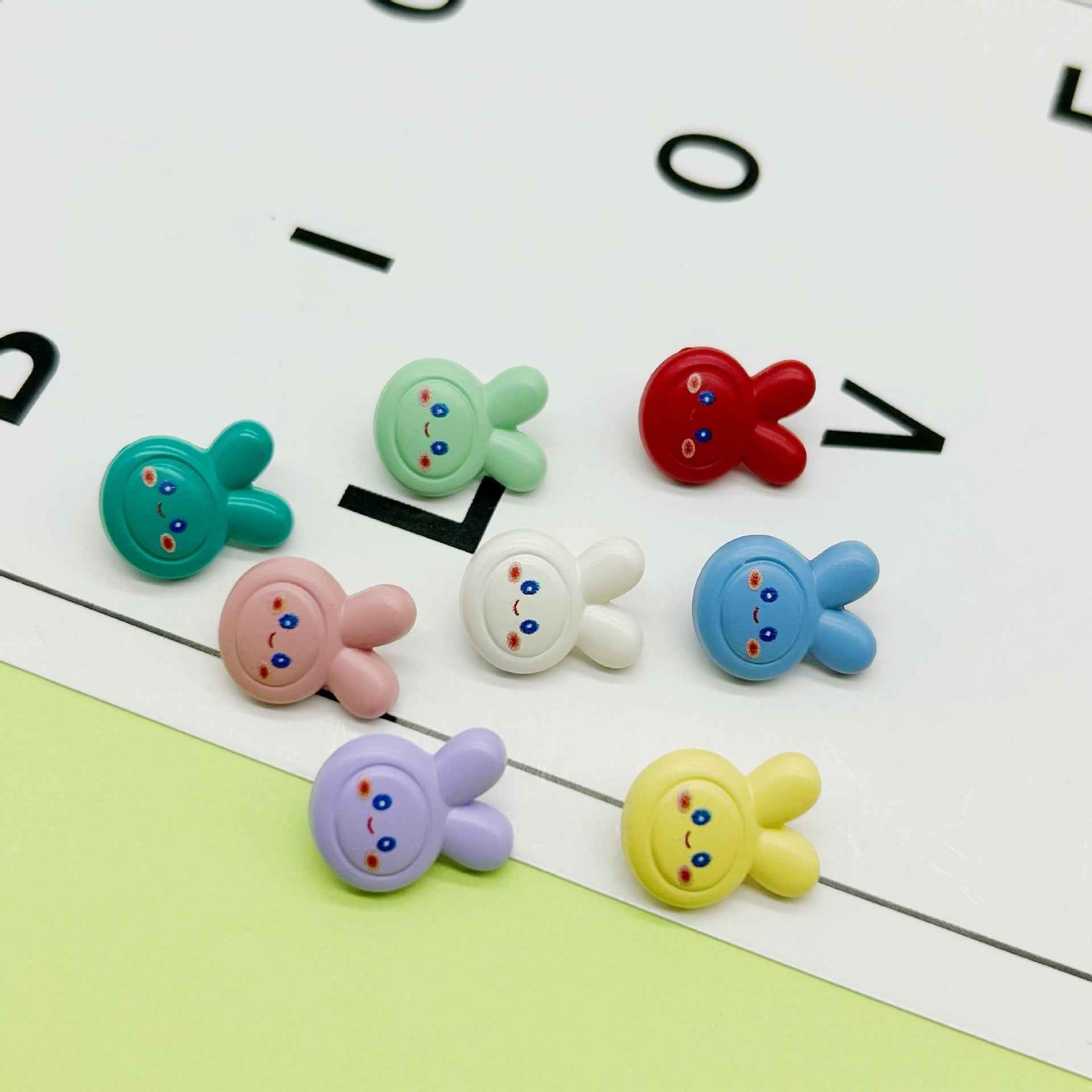 Colorful cartoon rabbit buttons set, round faces with two ears and small star cutout