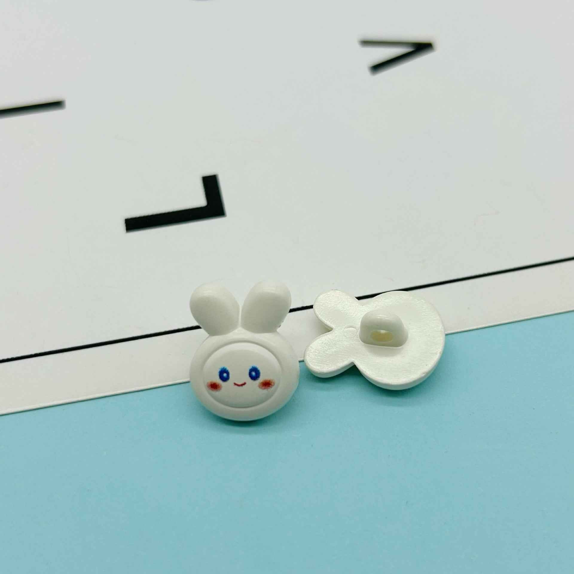 White cartoon rabbit buttons: bunny face with ears and white flower-shaped bow
