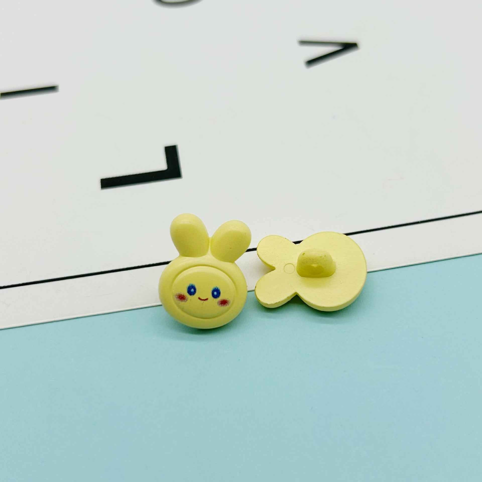 Yellow cartoon rabbit buttons: bunny face with ears and yellow flower-shaped bow