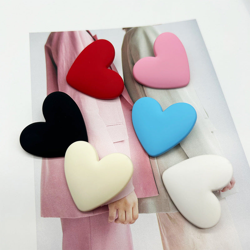 Colorful heart-shaped plastic buttons with shanks: red, pink, black, cream, blue.