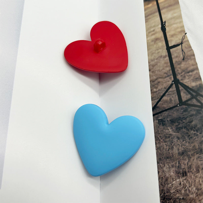 Heart-shaped plastic buttons with shanks: red and light blue heart fronts.