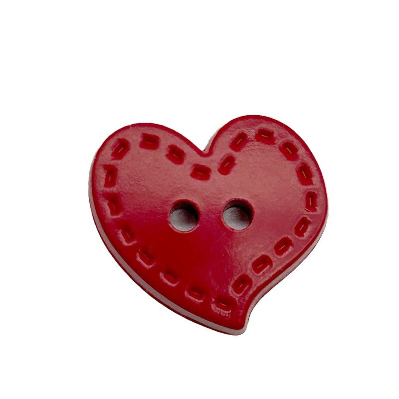 Red heart-shaped plastic button with dotted trim and two holes