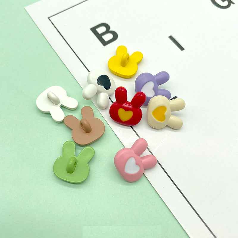 Assorted bunny-shaped plastic buttons in yellow, red, purple, beige, green, and pink