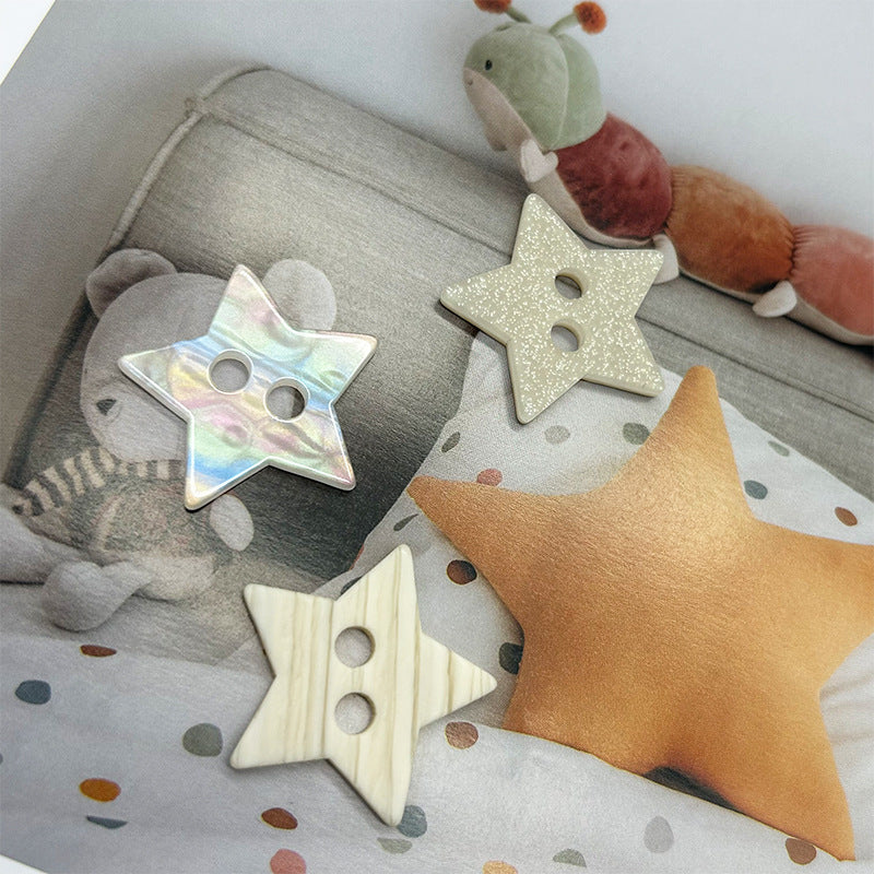 Star-shaped two-hole buttons on fabric, iridescent and beige finishes