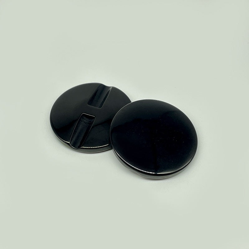 Two black resin concealed-hole buttons, flat backs with center slot