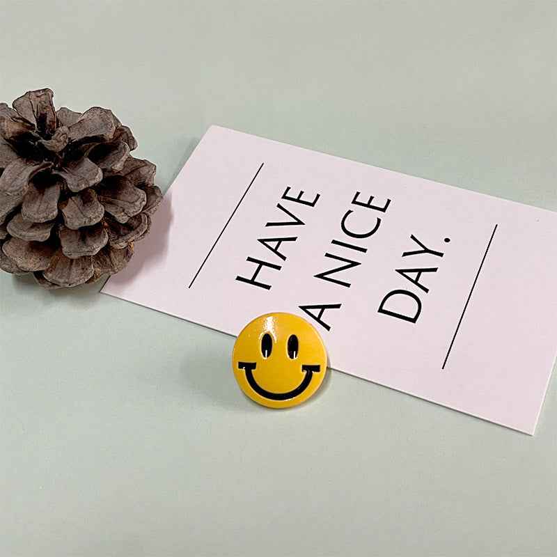 Yellow round smiley face button with shank for children’s tops