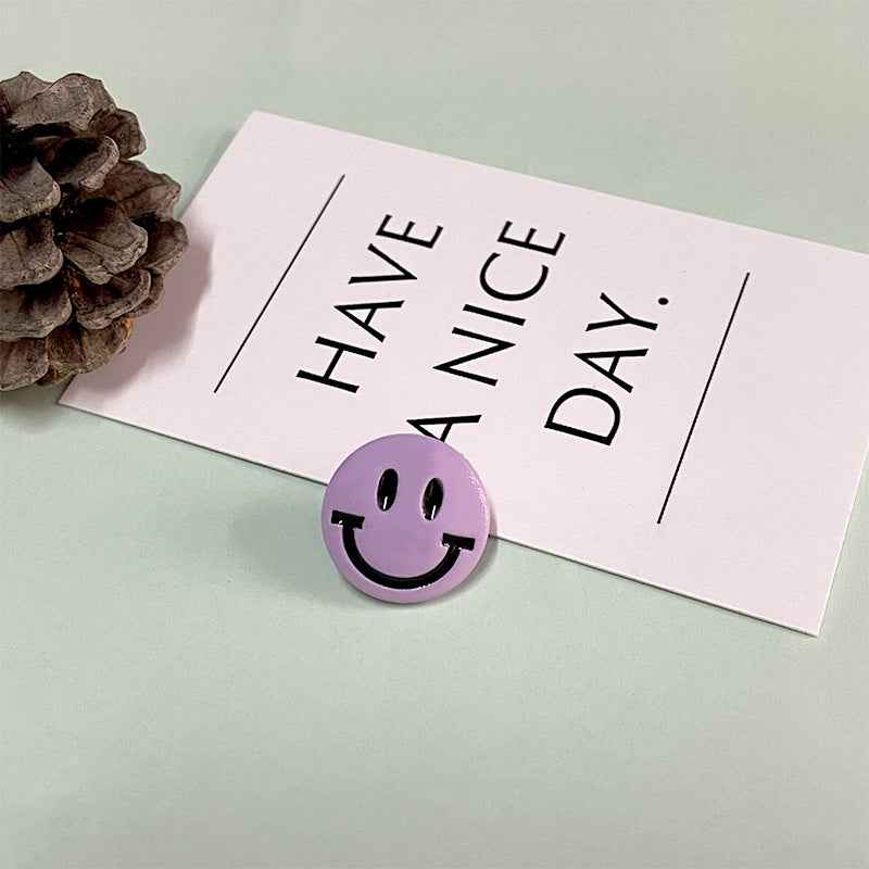 Purple round cartoon smiley face button with shank