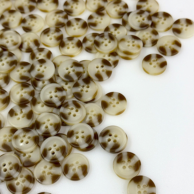 Round four-hole resin buttons in brown and cream marbled patterned finish.