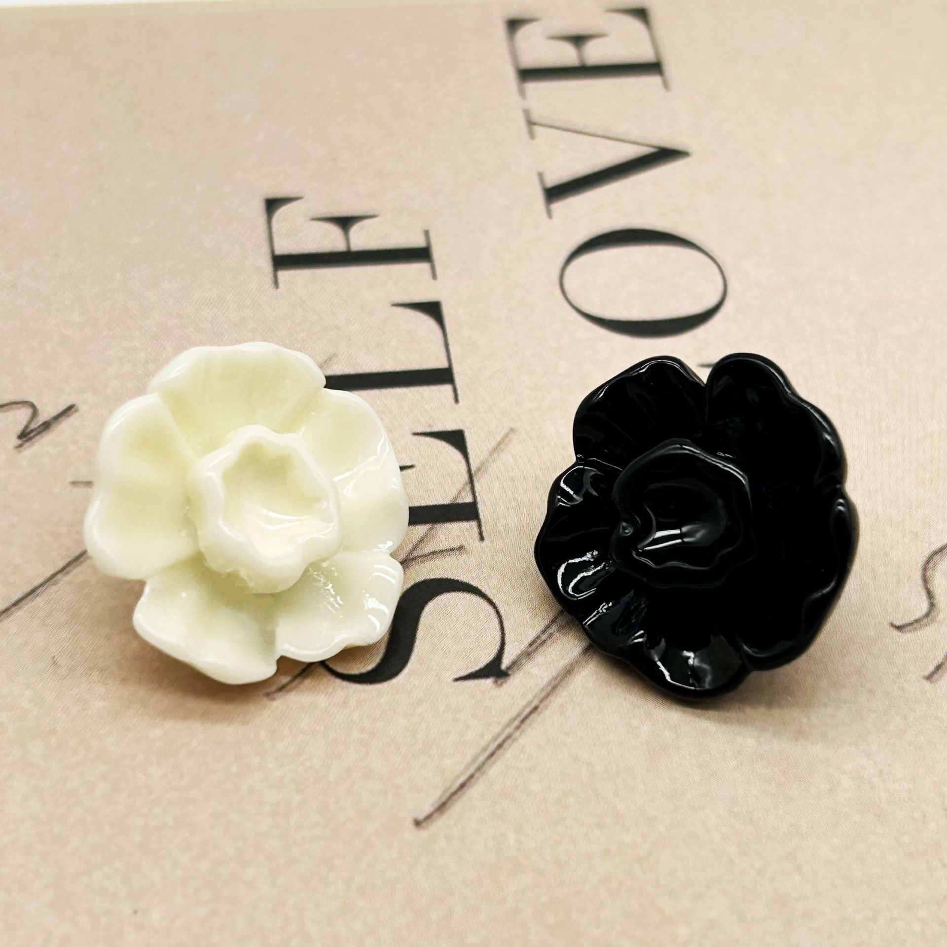 Black 3D flower button with metal shank, glossy layered petals