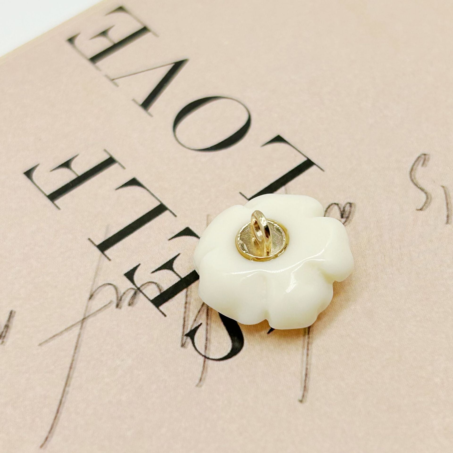 White 3D flower button with metal shank, view of back and pin