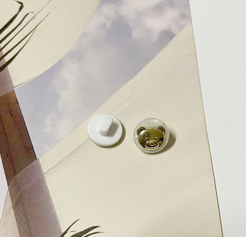 Round bear buttons with gold-tone motif and green-tinted resin face, two shown