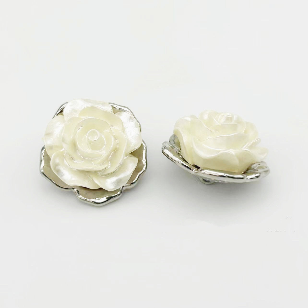 Rose-shaped alloy button with shank, ivory petals and silver-toned back