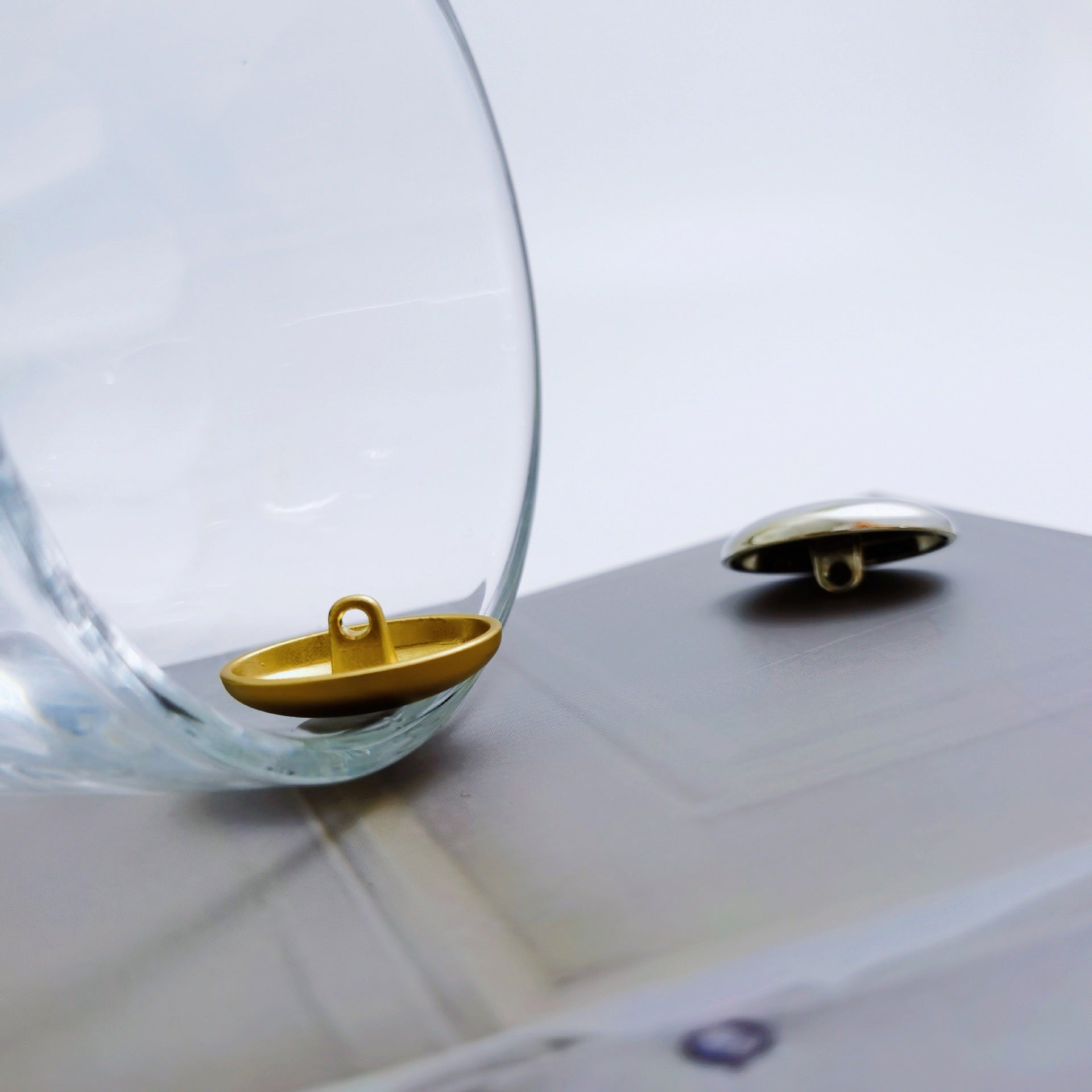 Light gold and silver oval buttons, smooth metal front with visible shank loops