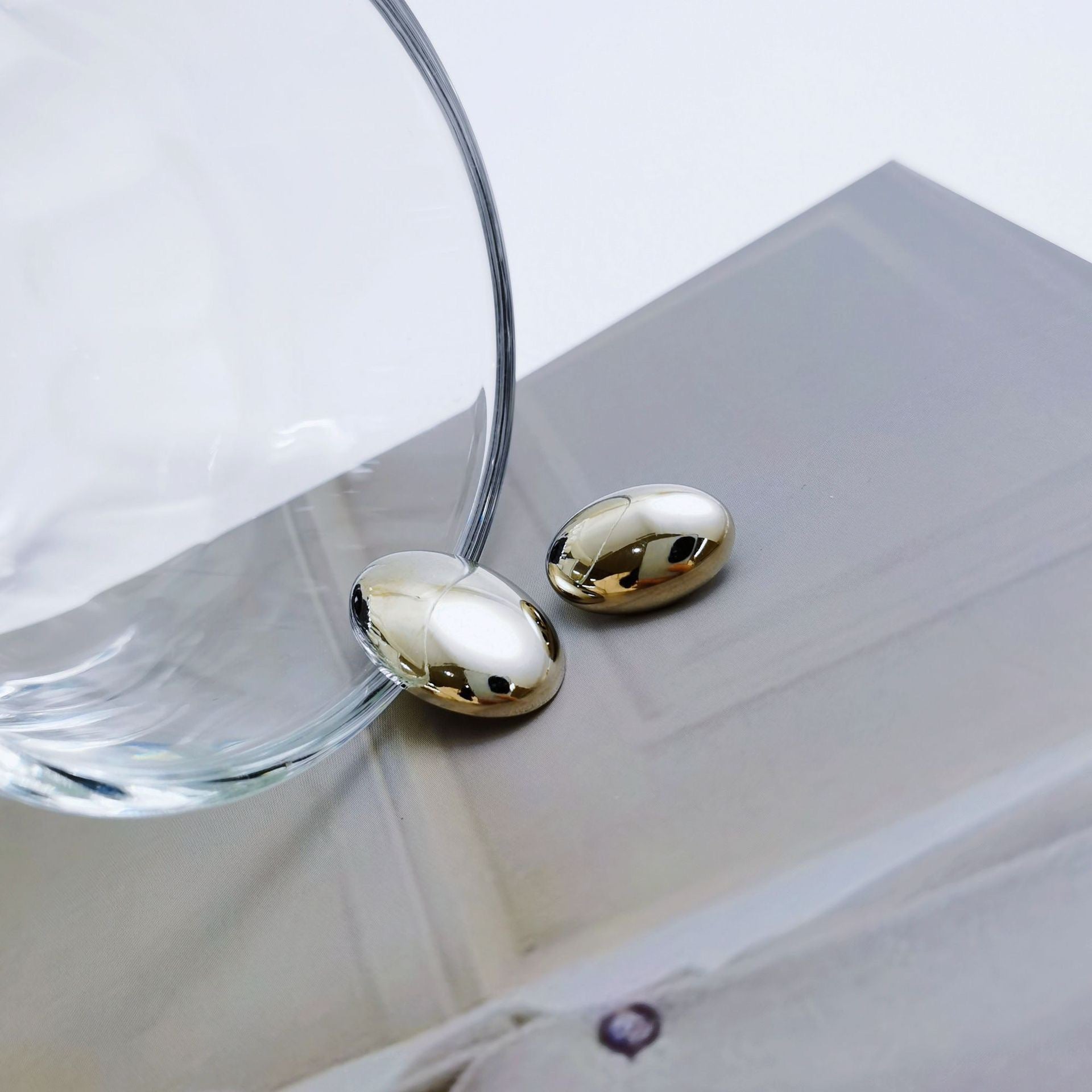 Silver oval metal buttons with shanks, smooth glossy oval fronts