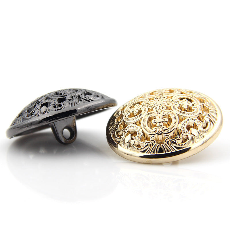 Metallknopf mit hohlem Schaft, goldfarbenes Vorderteil mit Ornamenten und schwarzer Rückseite