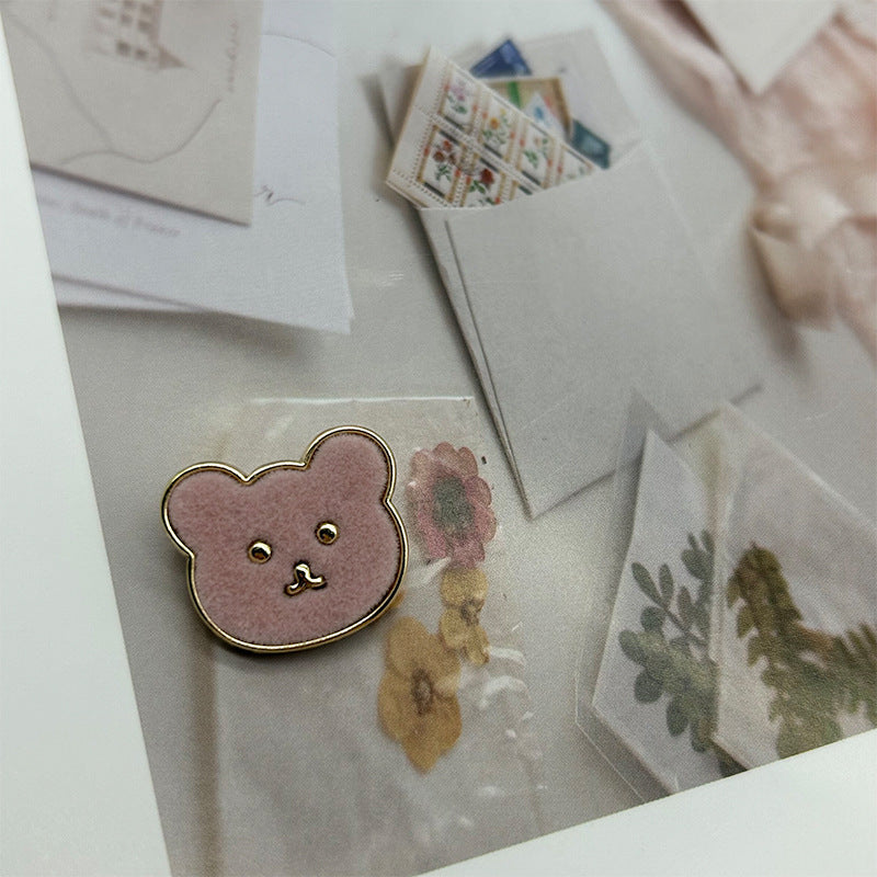 Pink teddy bear metal button with flannelette face and gold-tone outline