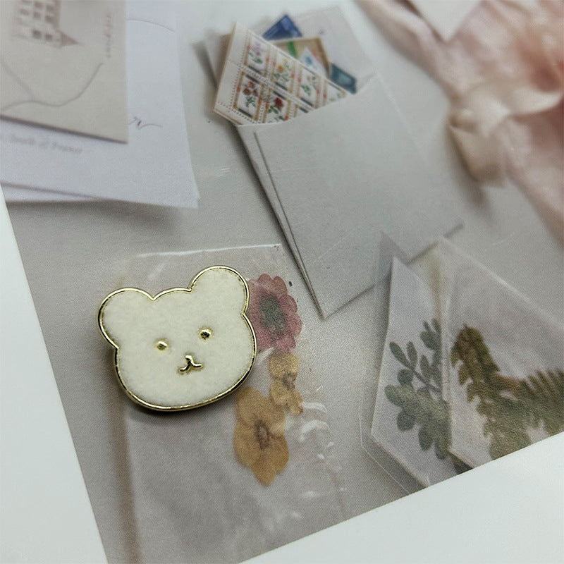 White teddy bear metal button with flannelette face and gold-tone outline