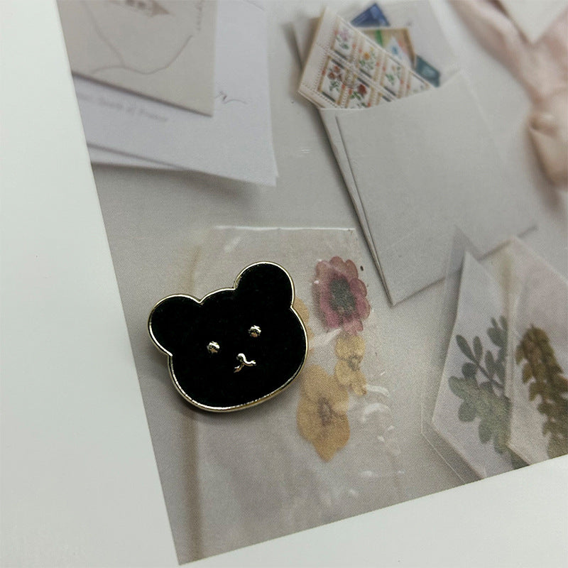 Black teddy bear metal button with flannelette face and gold-tone outline