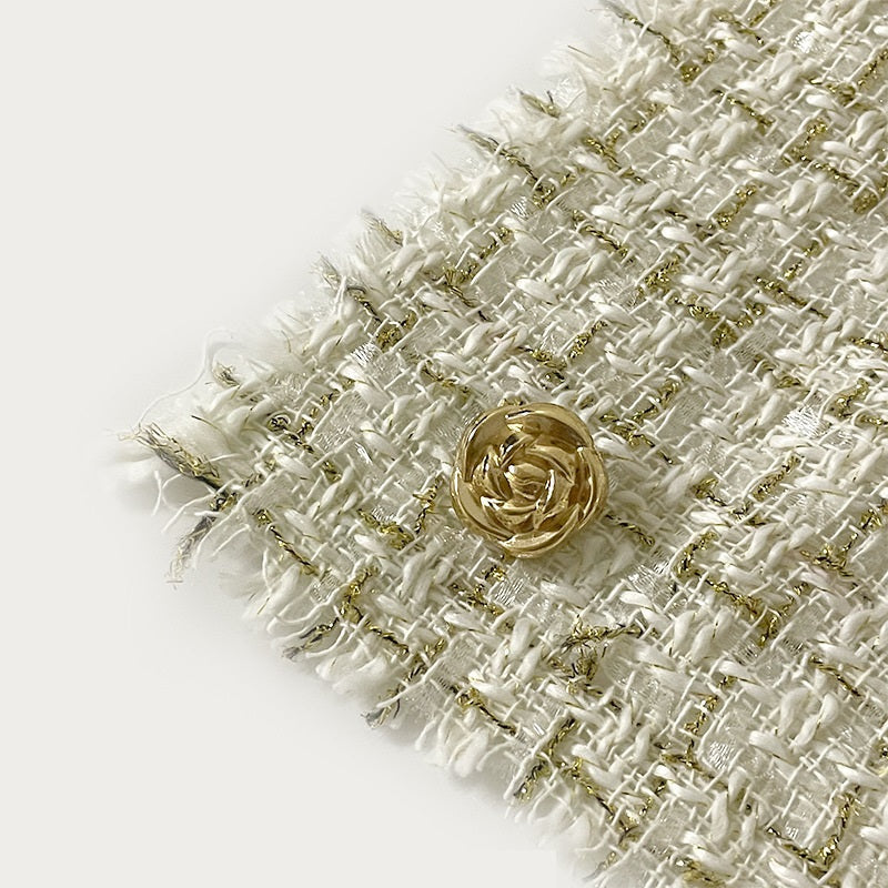 Bouton métal rose avec tige, doré clair, posé sur tissu texturé, vue rapprochée